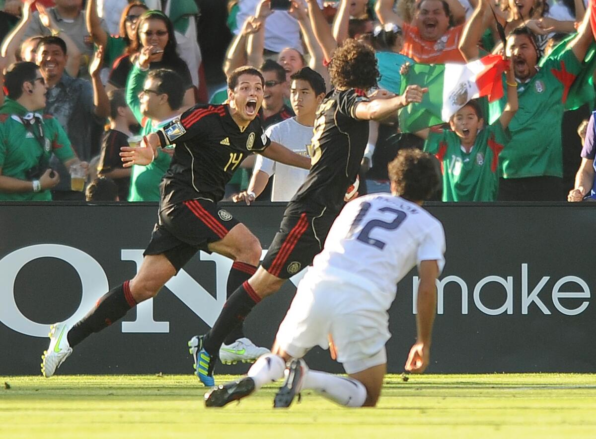 Skalij, Wally –– B581362974Z.1 PASADENA, CALIFONRIA JUNE 24, 2011–Mexico's Javier Hernandez, left, celebrates with goal scorer Andres Guardado in fron of USA's Jonathan Bornstein to tie the game in the 1st half of the Gold Cup Final at the Rose Bowl Saturday. (Wally Skalij/Los Angeles Times)