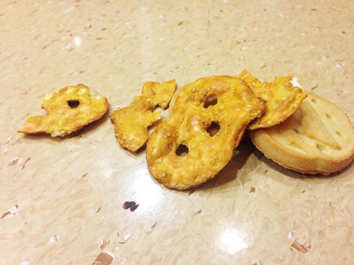 Some chips and cookies on a laminate floor.