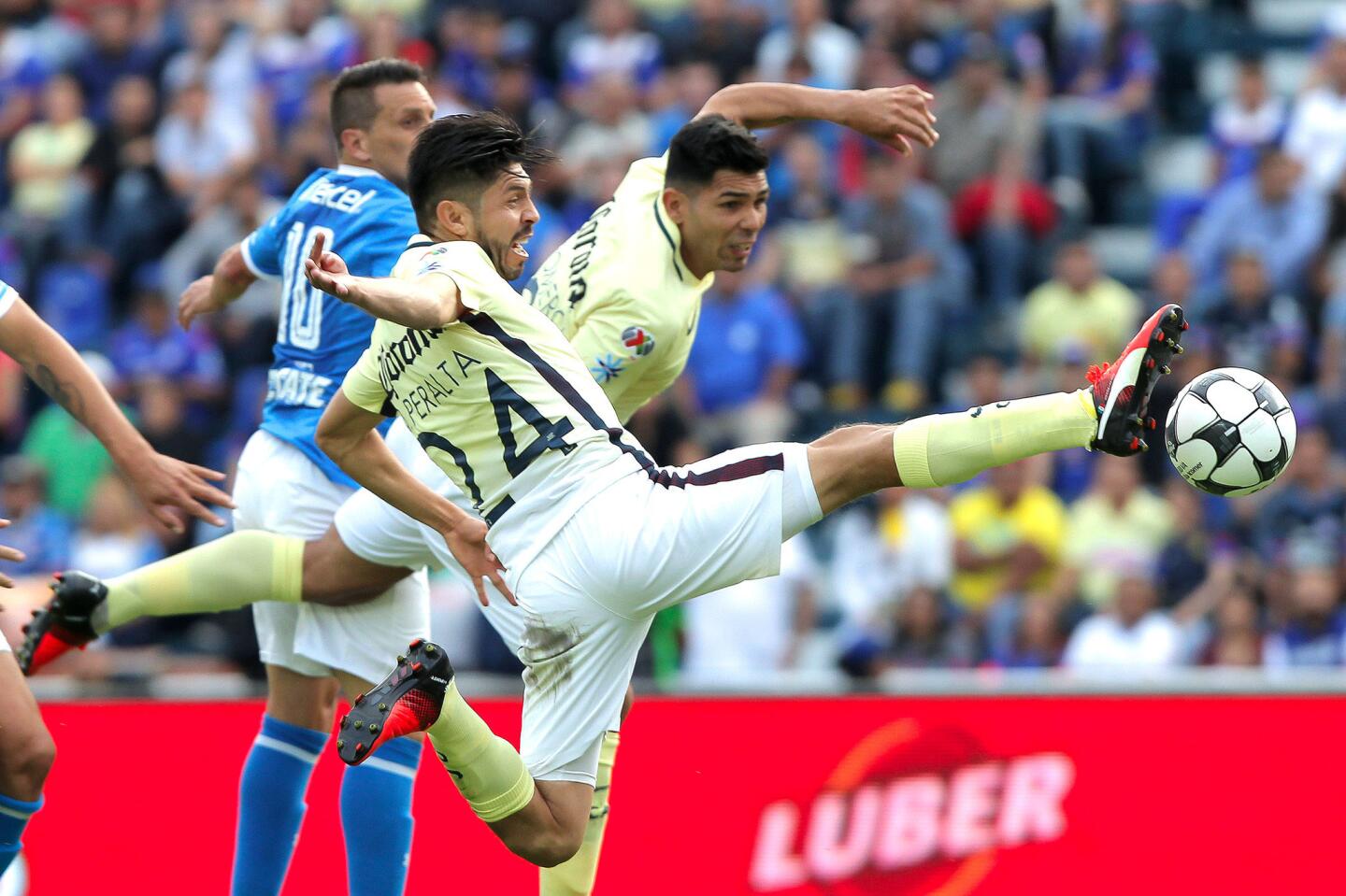 El jugador del América, Oribe Peralta (c), se lanzó y conectó el balón para anotarle a Cruz Azul, en juego correspondiente a la jornada ocho del futbol mexicano, en el estadio Azul de Ciudad de México.