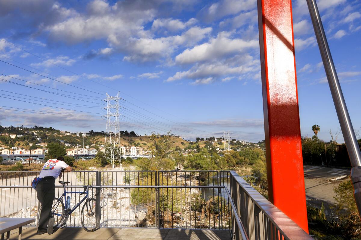 A bicyclist stops to take in the view from a bridge