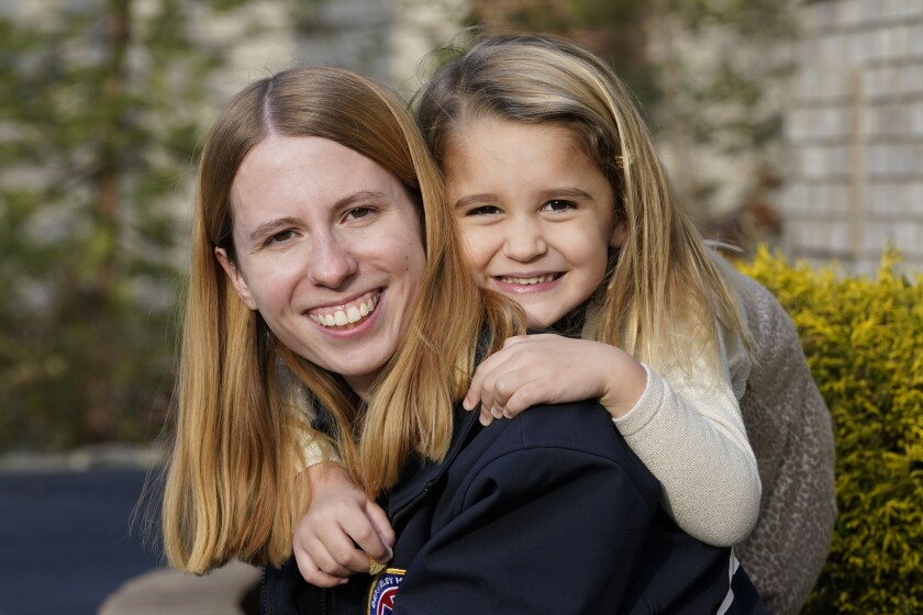 Nicole Segalini, left, and Ava Windt, 4, pose for a picture in New Providence, N.J., Monday, Dec. 6, 2021. Segalini delivered Ava on a cold March night nearly five years ago. The volunteer first responder - a high school senior at the time - was just months removed from learning how to deliver babies when she got to try the real thing. That emergency launched a friendship between total strangers that has lasted through Segalini's four years away at college, a major surgery and the pandemic. (AP Photo/Seth Wenig)