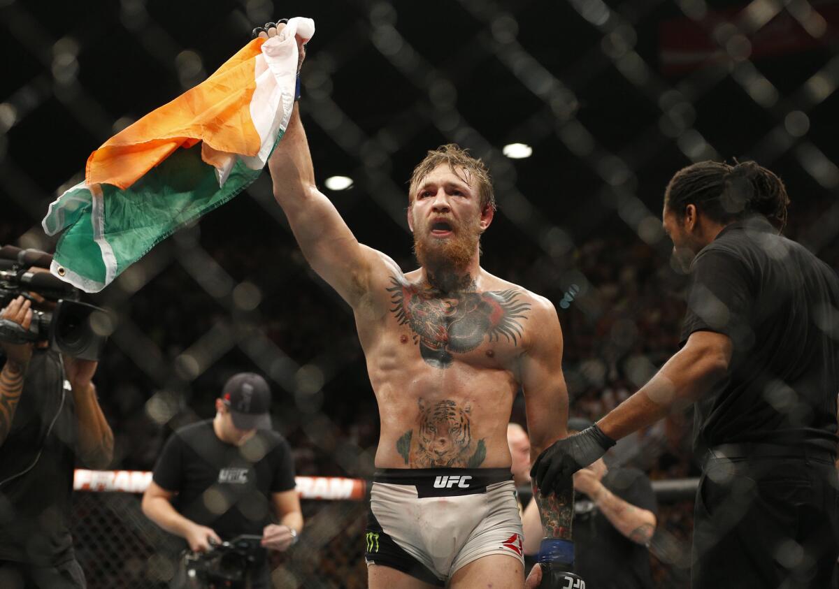 Conor McGregor hoists the flag of Ireland after defeating Chad Mendes for the interim featherweight title on Saturday night at UFC 189 in Las Vegas.