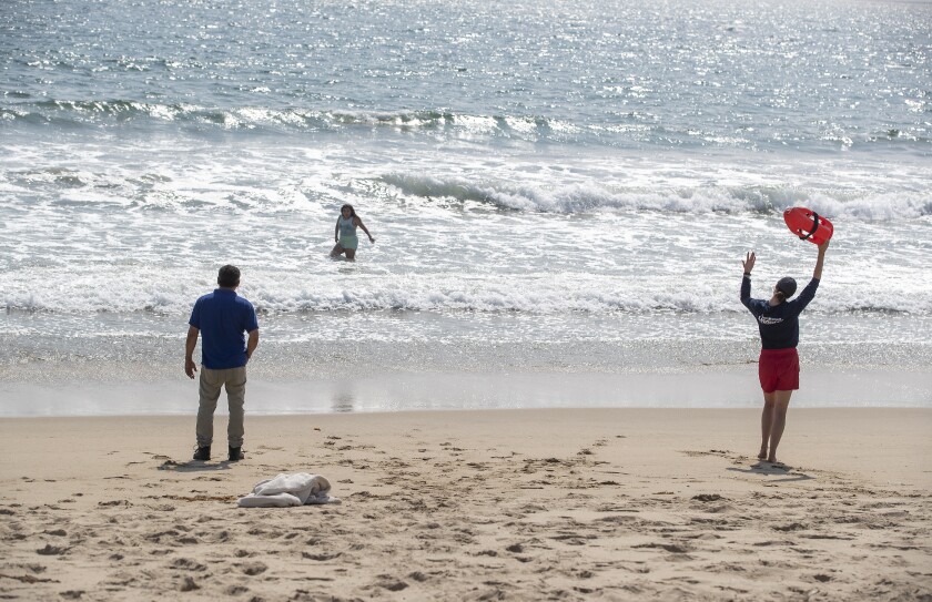A lifeguard calls to a person in the ocean.
