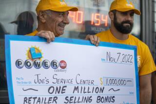 Altadena, CA - November 08: Joe Chahayed, (CH) left, holds up a check for $1,000,000. for the retailer selling bonus and Daniel Chahayed, right, at Joe's Service Center on Tuesday, Nov. 8, 2022, in Altadena, CA. Years ago Joe immigrated here from Syria he said. A single winning ticket for Monday night's delayed Powerball lottery drawing was sold in Altadena, with the jackpot worth a record-setting $2.04 billion, lottery officials confirmed today. (Francine Orr / Los Angeles Times)