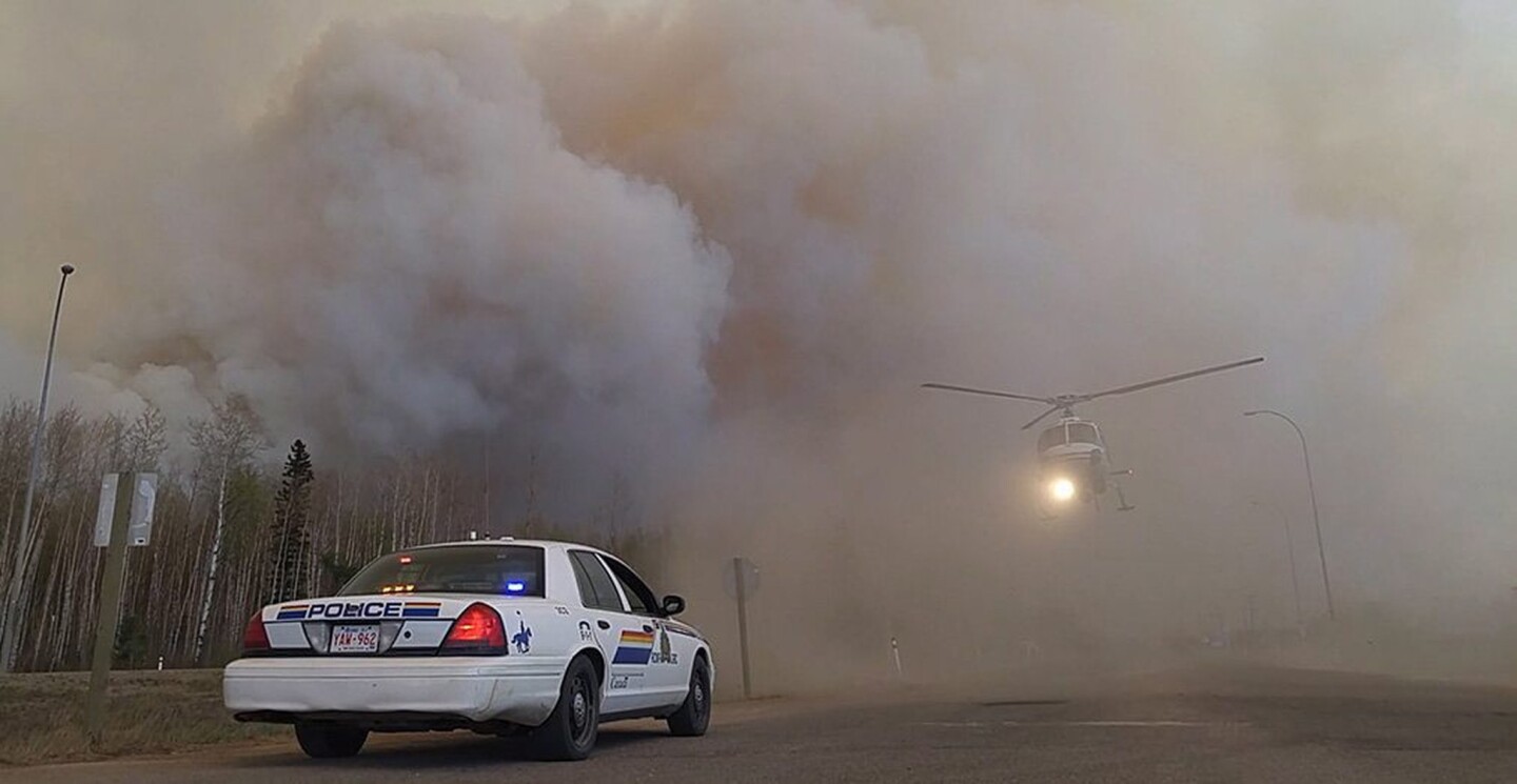 Royal Canadian Mounted Police officers carry out rescue and evacuation work near Fort McMurray.