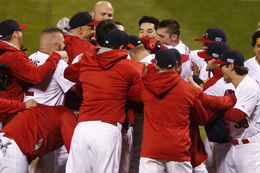St. Louis Cardinals players celebrate with teammate Kolten Wong following his winning home run in the ninth inning of a 5-4 win over the San Francisco Giants in Game 2 of the National League Championship Series on Sunday.