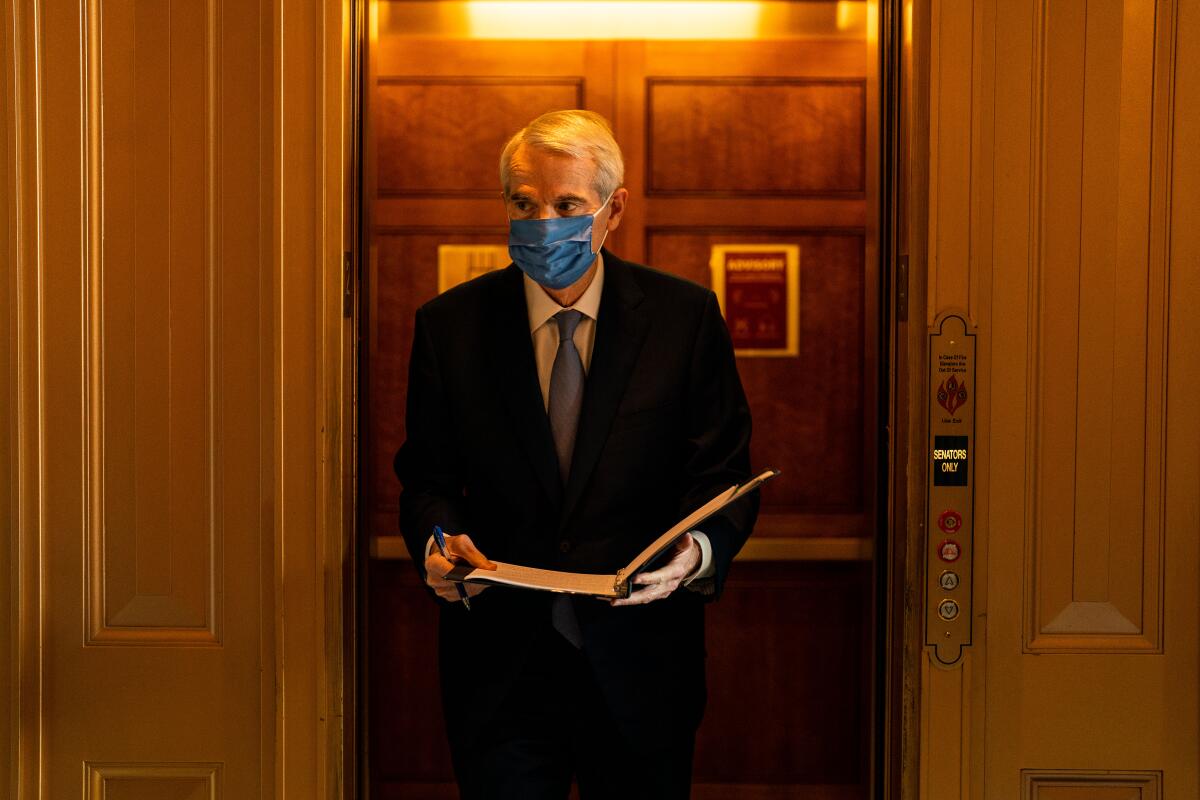 A person in a face mask exits an elevator.