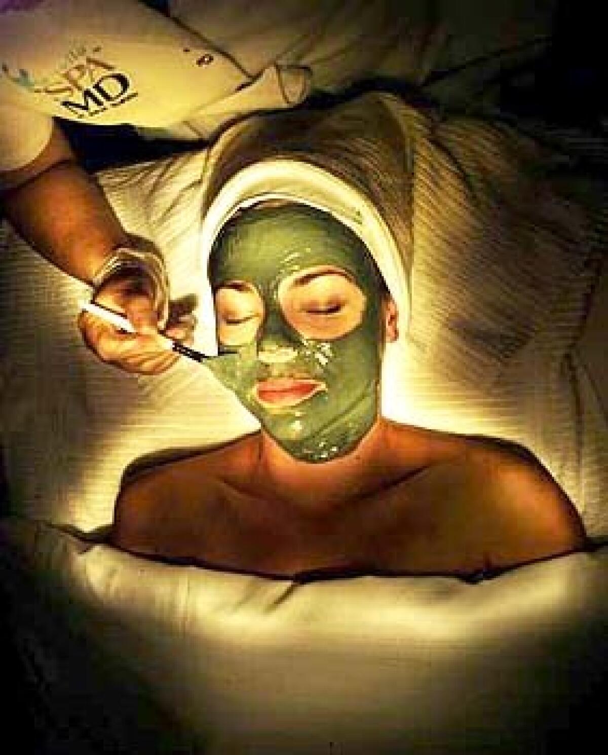 Aesthetician Afi Rowghani applies a mud mask as part of Nina Irigarays facial at Spa MD in La Jolla.