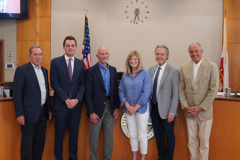 The Laguna Beach City Council poses for a picture with incoming city manager Dave Kiff, third from left, after his contract was approved on Tuesday, April 9, 2024.