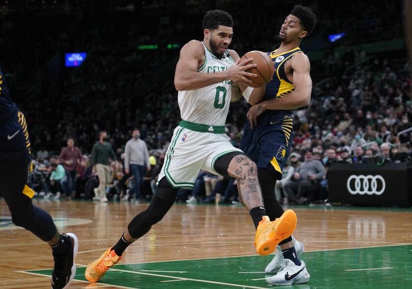 Boston Celtics forward Jayson Tatum (0) drives to the basket against Indiana Pacers guard Jeremy Lamb, right, during the first half of an NBA basketball game, Monday, Jan. 10, 2022, in Boston. (AP Photo/Charles Krupa)