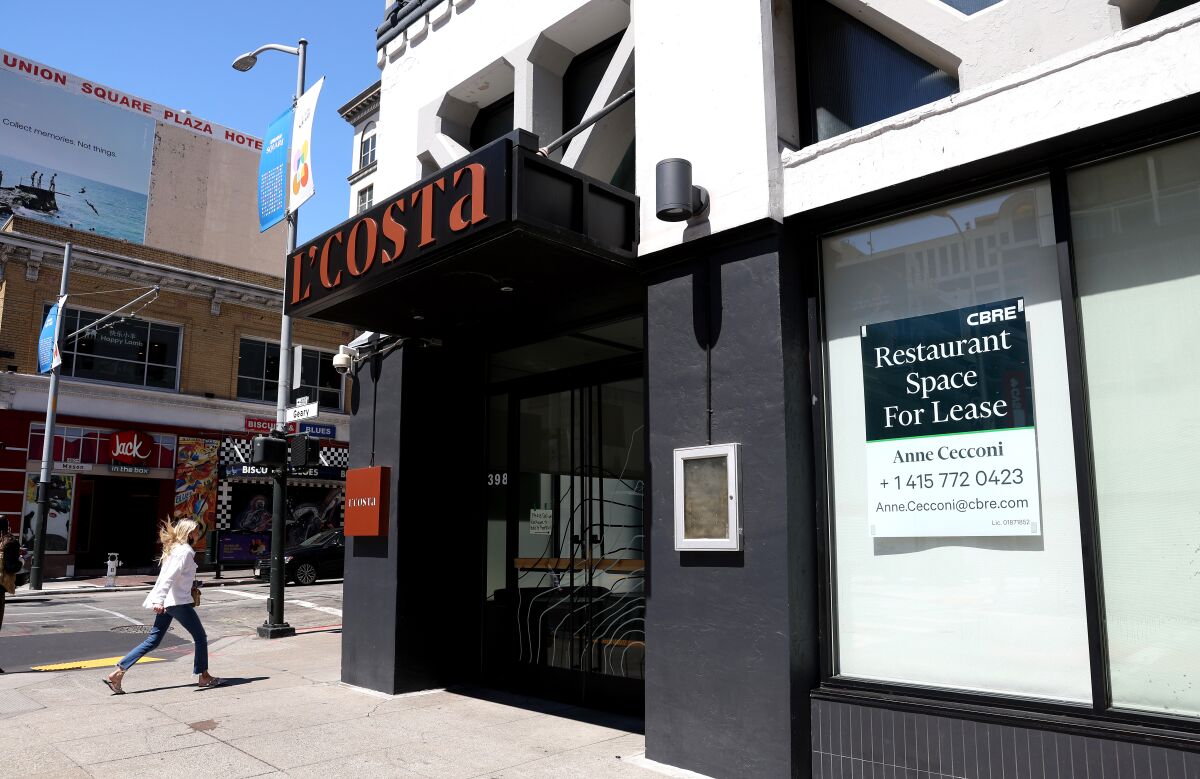A pedestrian walks by a closed business with a sign in the window: Restaurant space for lease