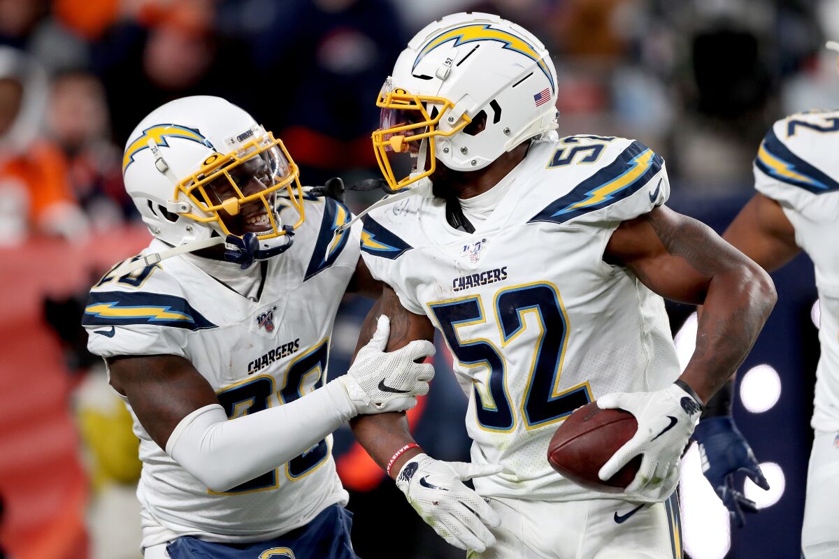 Chargers linebacker Denzel Perryman celebrates with Desmond King II after intercepting a pass during a game against the Broncos on Dec. 1.