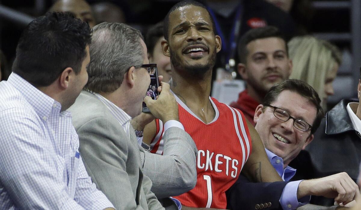 Houston's Trevor Ariza has some fun with fans after chasing a loose ball into the seats Monday in Philadelphia.