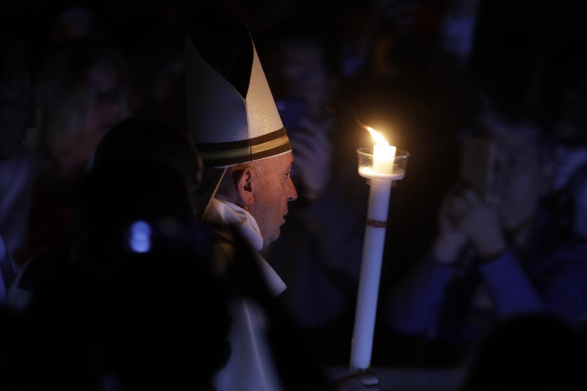 El Papa Francisco sostiene una vela mientras preside una ceremonia solemne de vigila de Pascua en la Basílica de San Pedro en el Vaticano.
