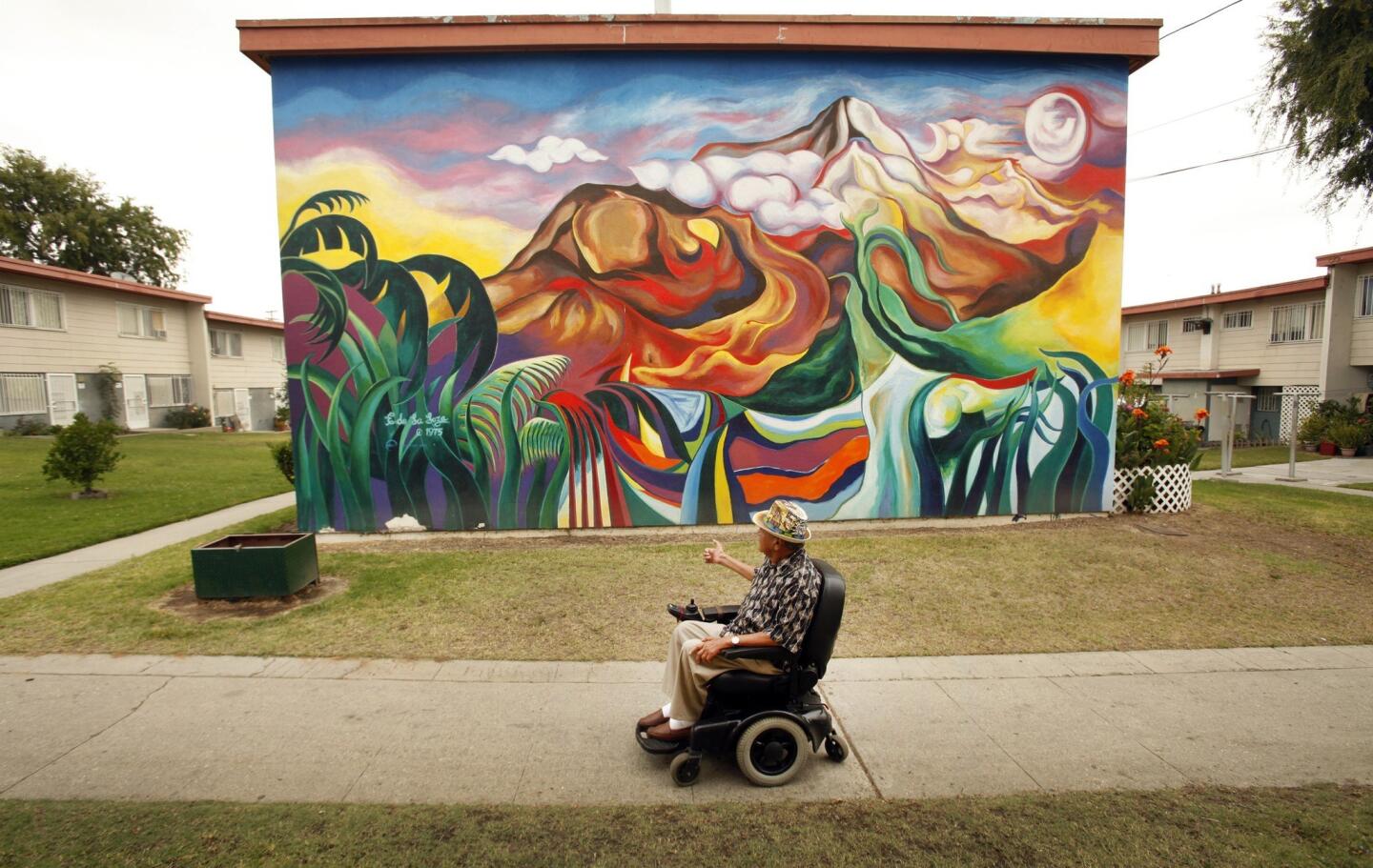 Oscar Eagle, 70, visits some of the murals he helped organize in 1973 that decorate the homes in Estrada Courts, located at Olympic Boulevard and Lorena Street in Boyle Heights.