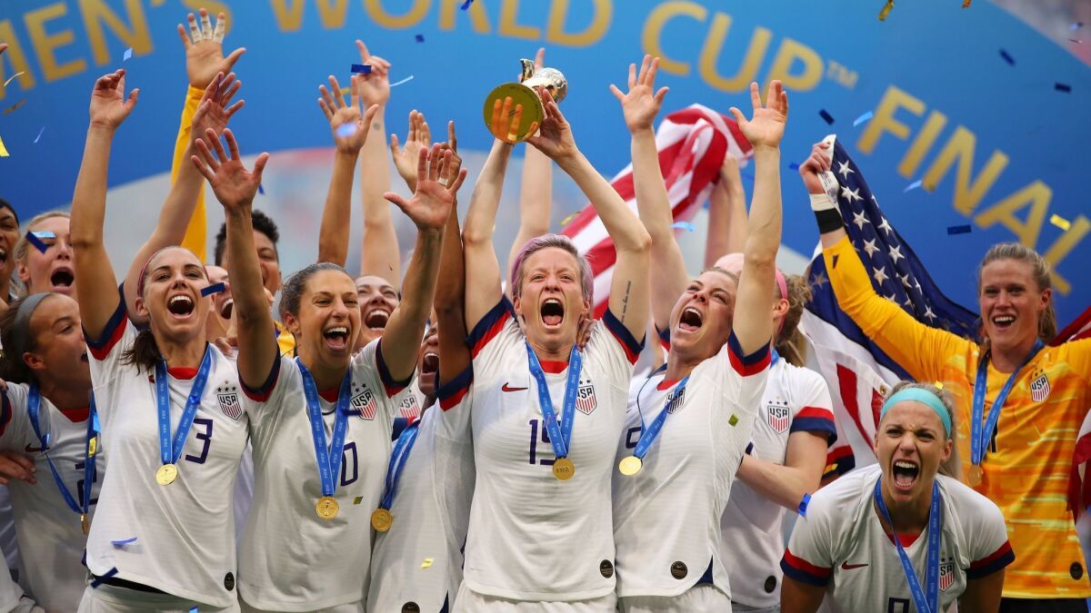 Megan Rapinoe, holding the trophy, and her U.S. teammates celebrate their 2-0 victory over the Netherlands in the Women’s World Cup final on July 7.