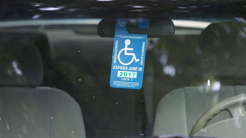 A handicap placard hangs in a vehicle parked in Sacramento on April 18, 2017.