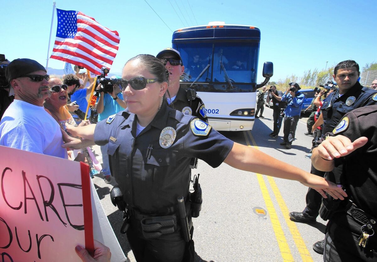 Demonstrators favoring stricter immigration enforcement block busloads of recently arrived women and children near a Border Patrol processing station in Murrieta, Calif., last summer.