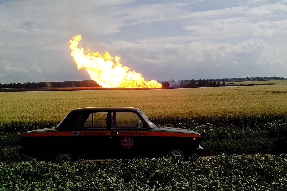 A police car parked near the site of a gas pipeline explosion and fire Tuesday near Poltava in central Ukraine.