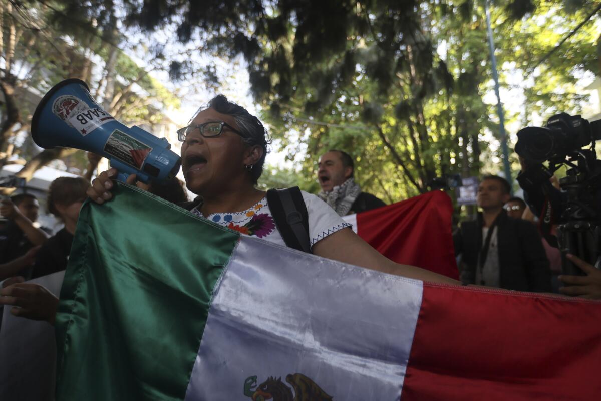 People protest outside the Ecuadorean Embassy in Mexico City.