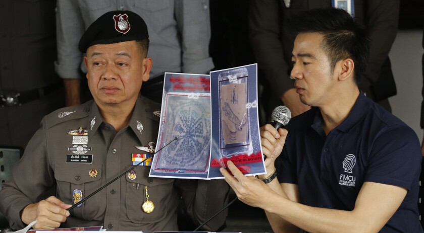 Thai police officers show pictures of a tattooed human skin during a news conference in Bangkok. Two pieces of skin and three other body parts were found in three packages bound for the United States.