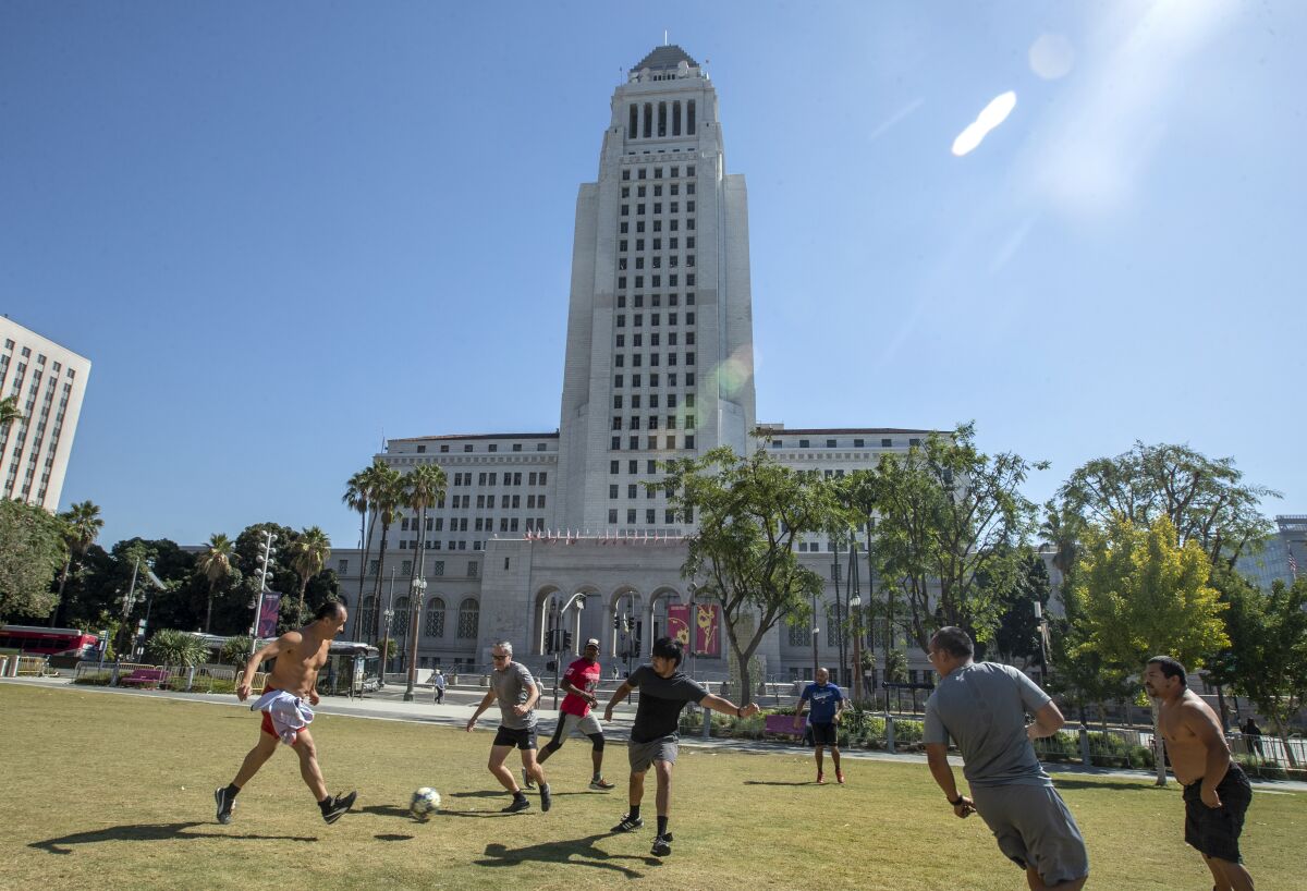 People play soccer grass in front of Los Angeles City Hall.