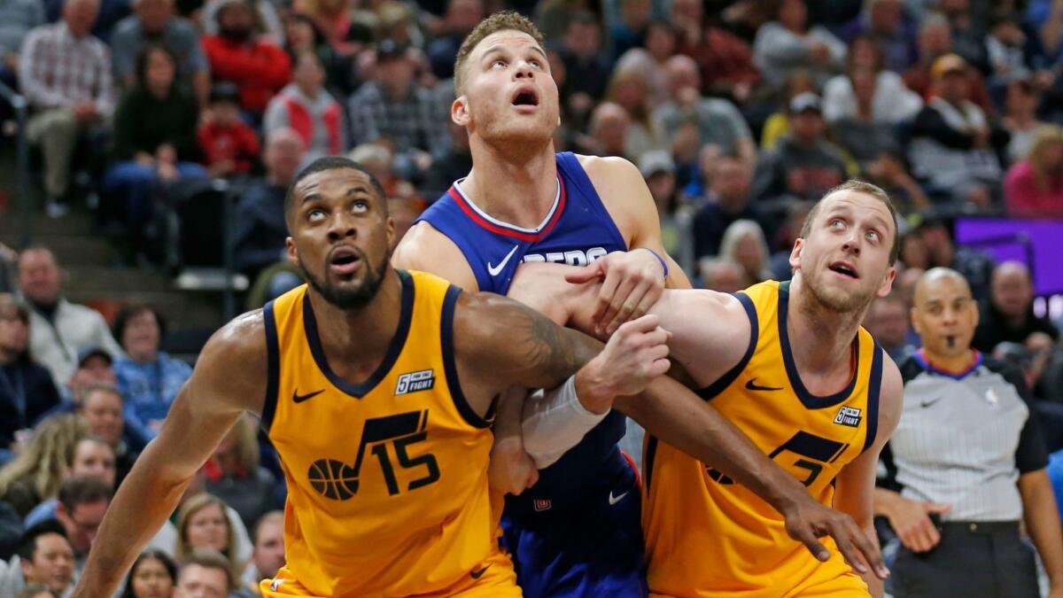 Blake Griffin battles under the boards with Utah Jazz's Derrick Favors (15) and Joe Ingles in the first half.