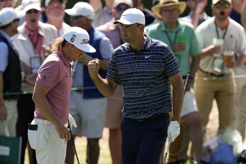 FILE - Scottie Scheffler pumps his fist as walks past Cameron Smith, of Australia, after a birdie chip on the third hole during the final round at the Masters golf tournament on Sunday, April 10, 2022, in Augusta, Ga. The hole was the turning point in Scheffler winning the Masters this year. (AP Photo/Robert F. Bukaty, File)