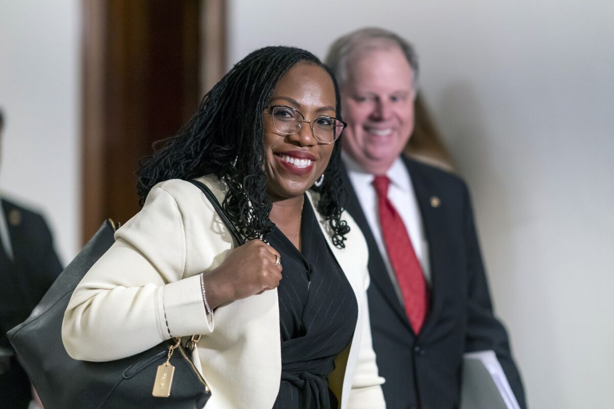 FILE - Supreme Court nominee Ketanji Brown Jackson smiles as she arrives for a meeting with Sen. Ben Sasse, R-Neb., a member of the Judiciary Committee, at the Capitol in Washington, March 3, 2022. Former Alabama Sen. Doug Jones has guided Jackson through the process of courting senators and preparing for her confirmation hearing that opens Monday. (AP Photo/J. Scott Applewhite, File)