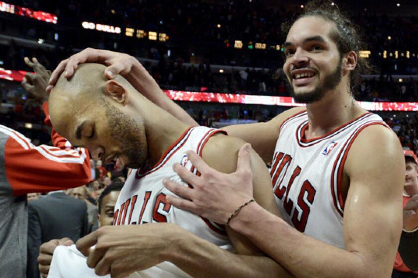 Taj Gibson, left, is congratulated by Bulls teammate Joakim Noah after hitting a winning shot in overtime to defeat the Lakers, 102-100, on Jan. 20, 2014.