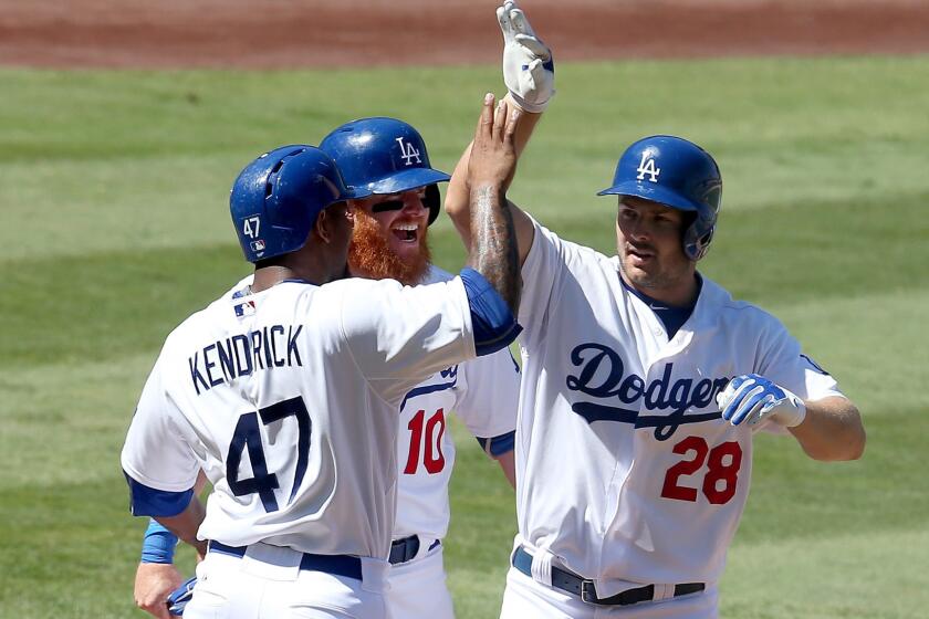 Dodgers outfielder Chris Heisey (28) is congratulated by teammates Justin Turner (10) and Howie Kendrick after hitting a grand slam against the Diamondbacks in the fifth inning Thursday afternoon.