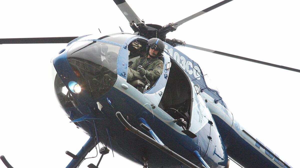 In this 2013 file photo, a Glendale police officer pilots a helicopter shared between the Burbank and Glendale police departments.