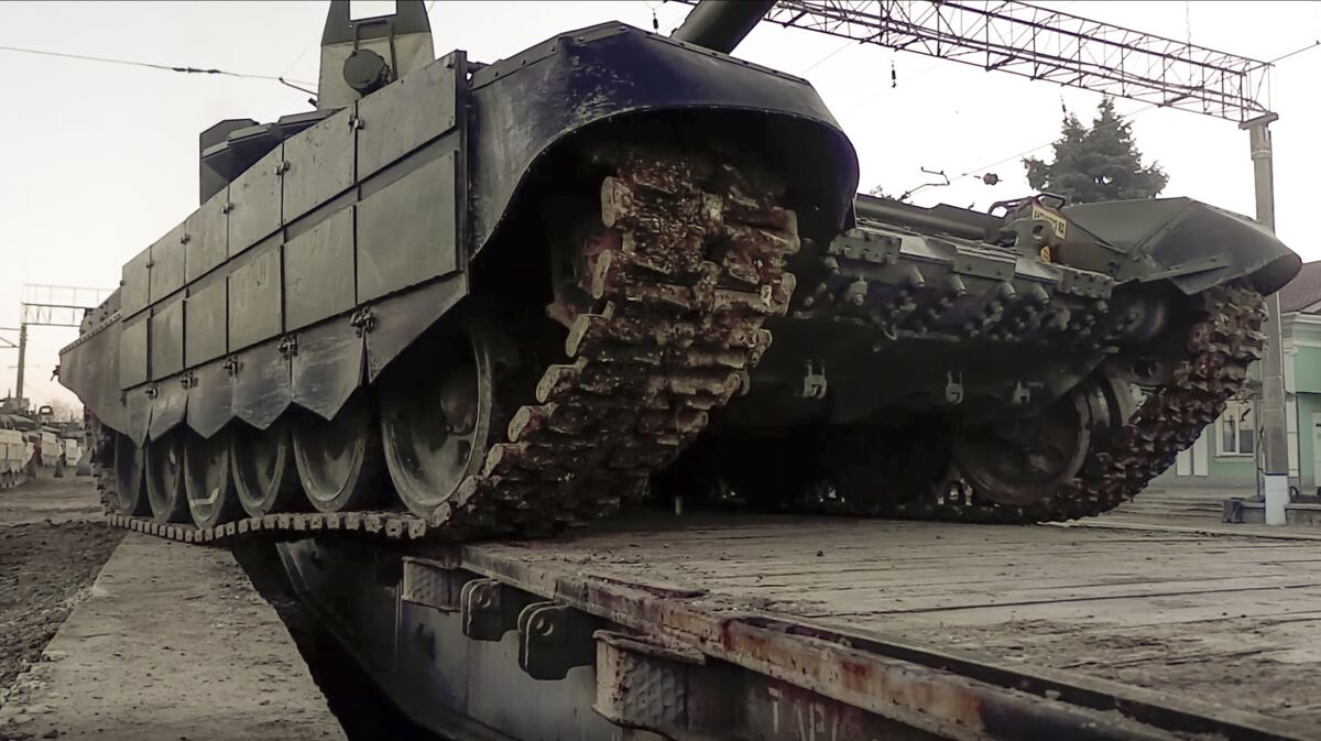In this photo taken from video provided by the Russian Defense Ministry Press Service on Tuesday, Feb. 15, 2022, A Russian tank is loaded onto railway platforms after the end of military drills in South Russia. In what could be another sign that the Kremlin would like to lower the temperature, Russia's Defense Ministry announced Tuesday that some units participating in military exercises would begin returning to their bases. (Russian Defense Ministry Press Service via AP)