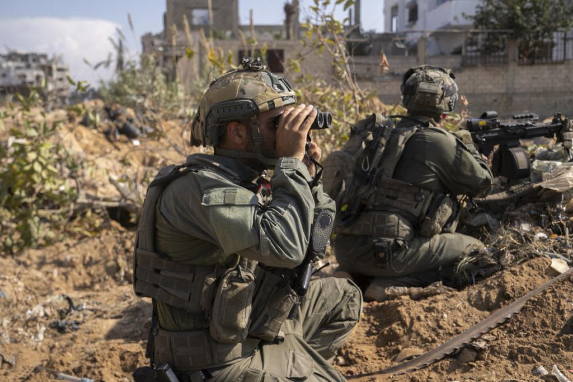Israeli soldier looking through field glasses in Gaza