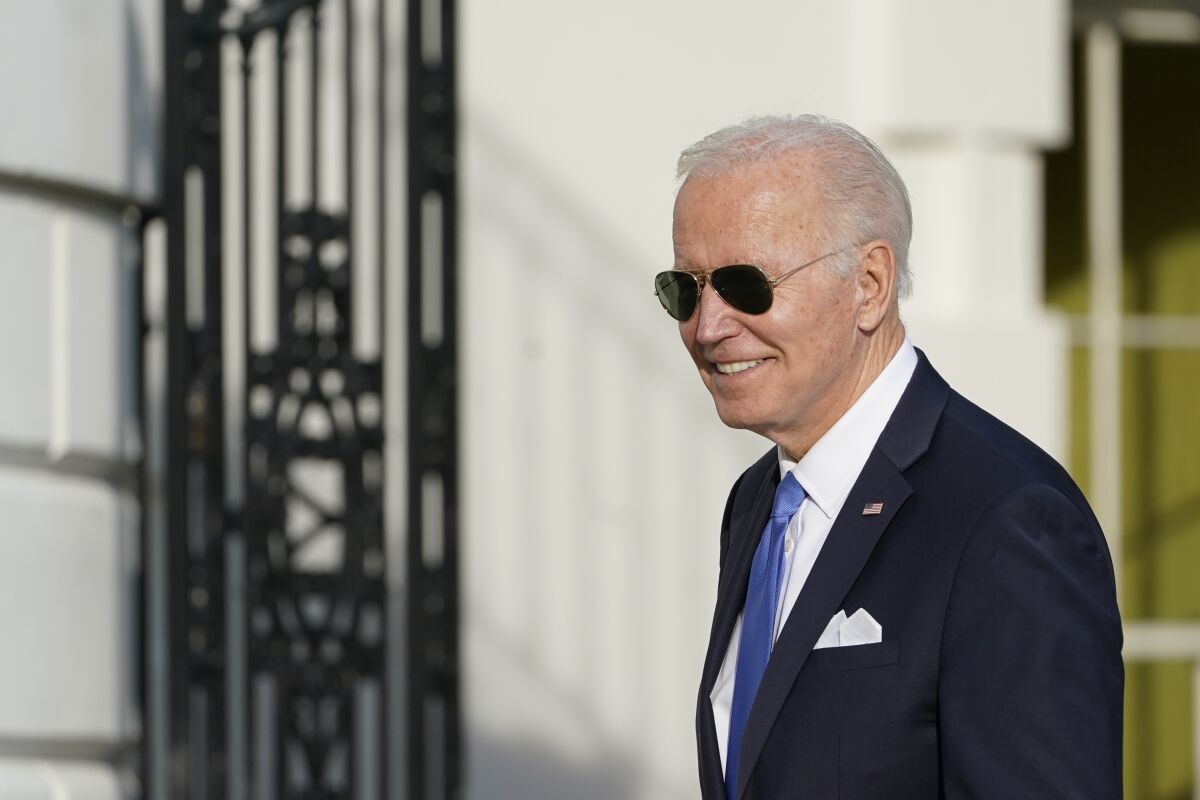 President Biden smiles wearing sunglasses.
