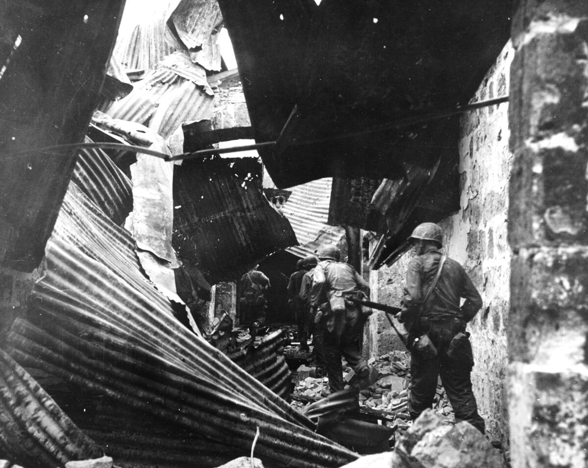 U.S. infantrymen conduct a house-to-house search during the Battle of Manila in 1945.