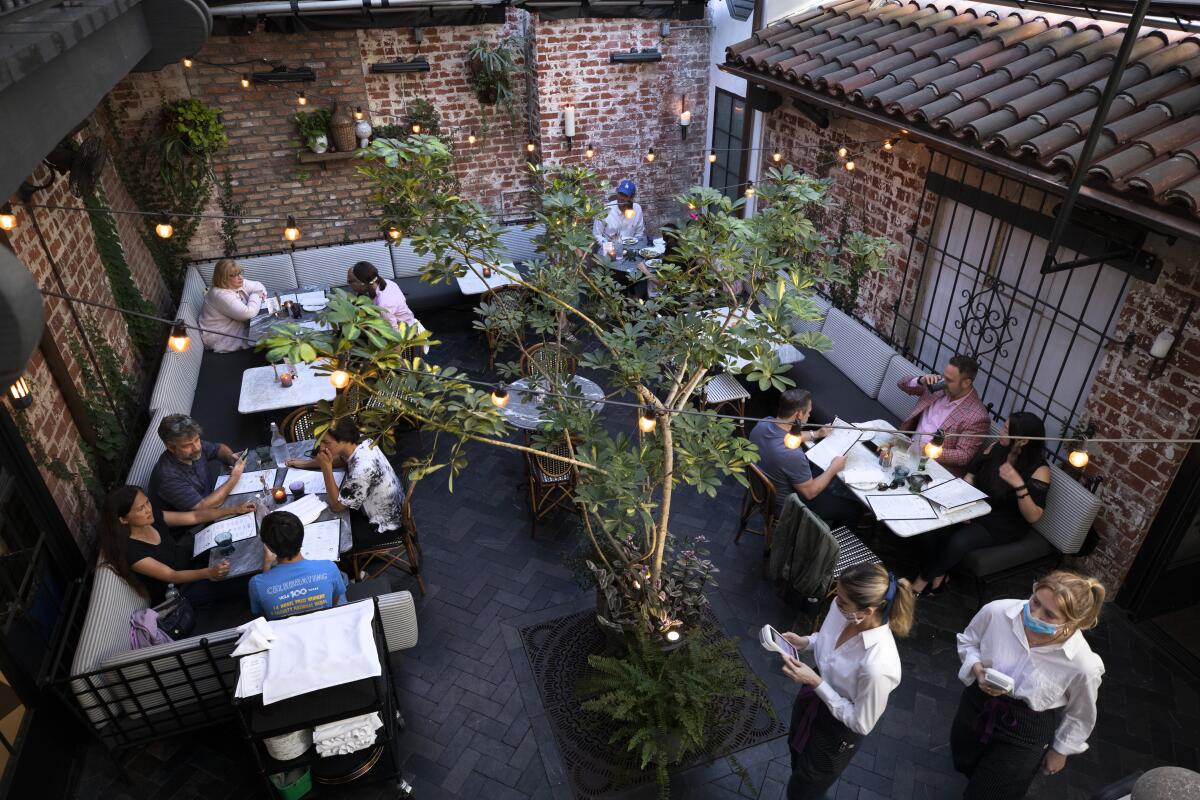 People dine in a restaurant's courtyard area.