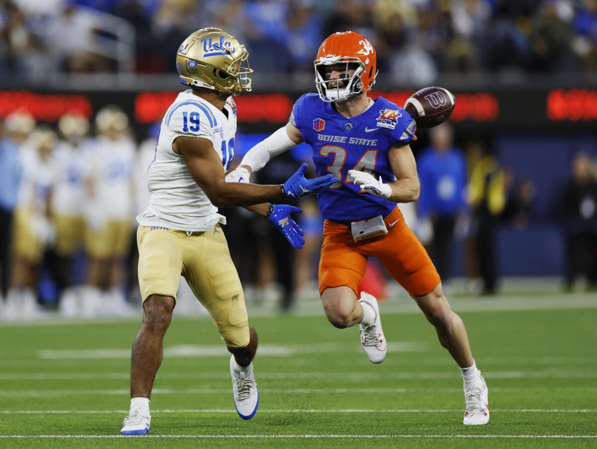 Boise State safety Alexander Teubner, right, blocks a pass intended for UCLA wide receiver Kyle Ford.