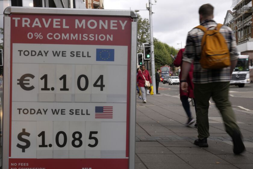 ARCHIVO - Peatones pasan junto a un cartel con tipos de cambio ante un establecimiento en Londres, el 23 de septiembre de 2022. (AP Foto/Kirsty Wigglesworth, Archivo)