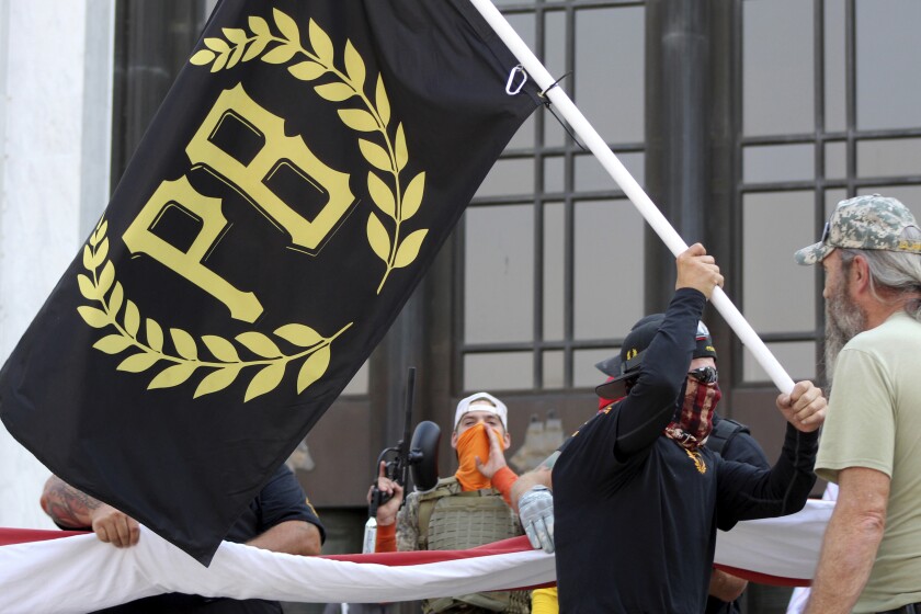 A protester carries a Proud Boys banner