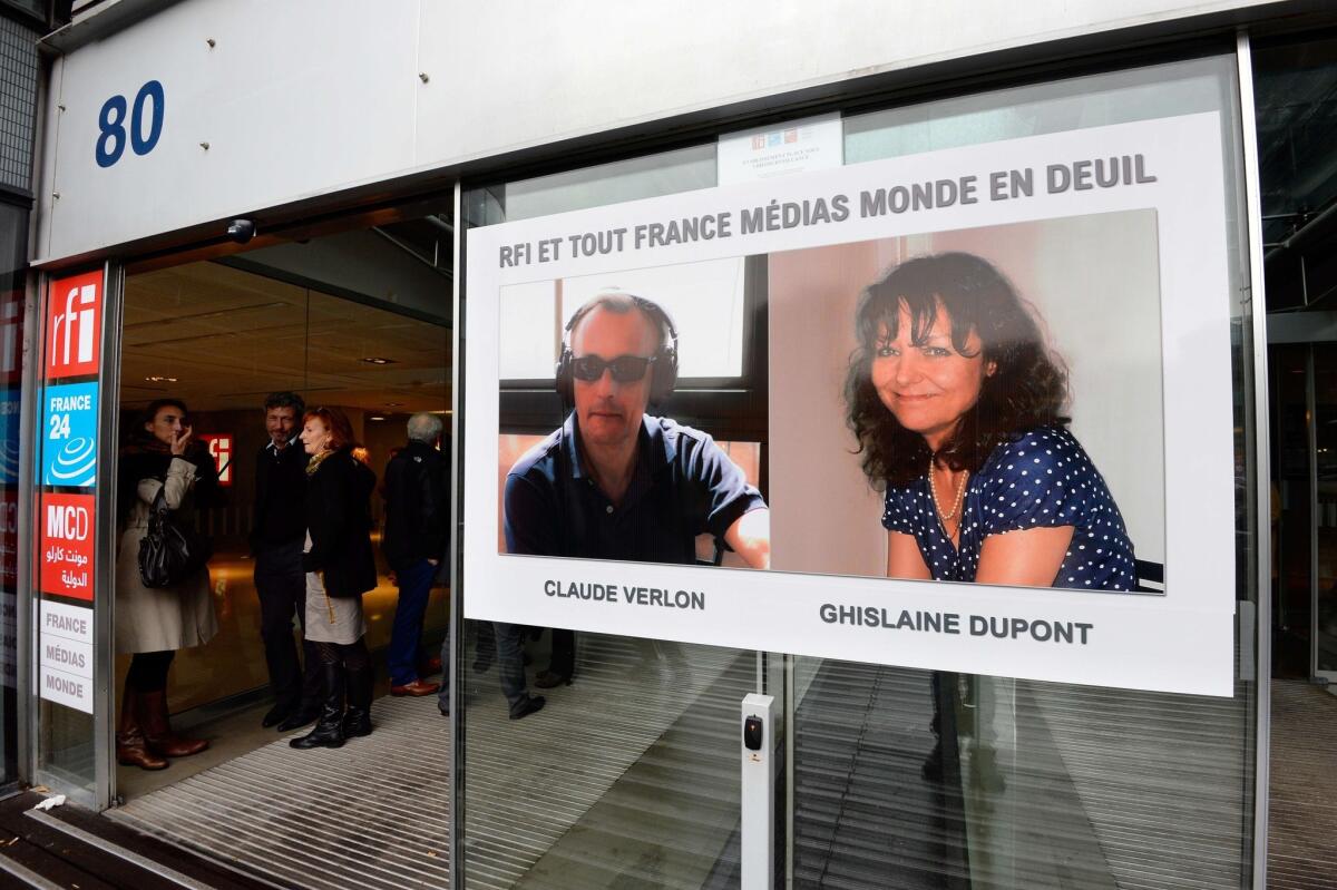 The portraits of two French journalists killed in Mali are displayed at the headquarters of Radio France International in Issy-les-Moulineaux, near Paris.