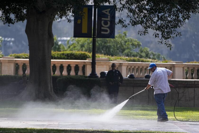 Un hombre limpia el suelo luego de que la policía retiró un campamento de protesta propalestino en el campus de la Universidad de California en Los Ángeles, el jueves 2 de mayo de 2024. (AP Foto/Mark J. Terrill)