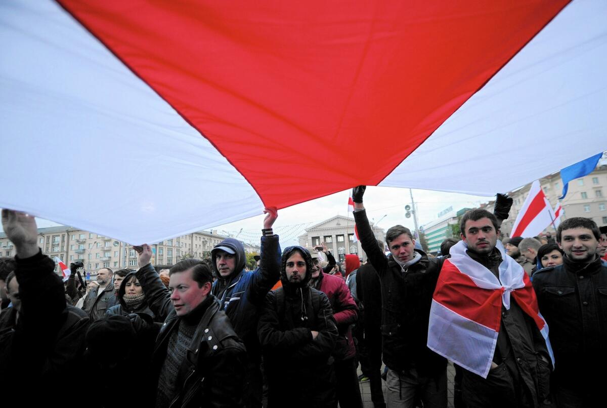 Opposition activists carry a giant opposition flag during a rally in central Minsk on Oct. 10, 2015 on the eve of Belarus' presidential election.