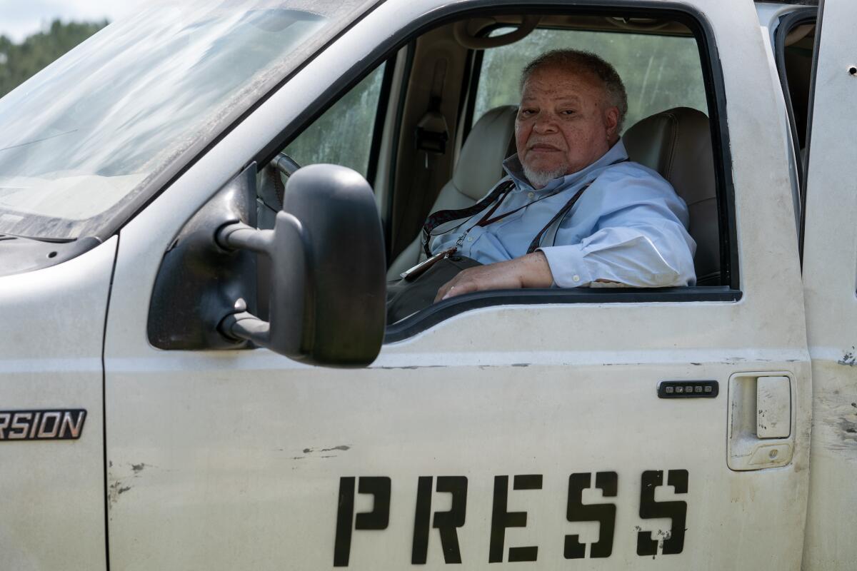 A journalist sitting behind the wheel of a press truck.