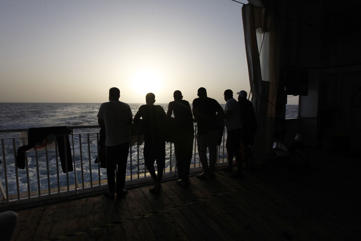 FILE - In this Sept. 22, 2021 file photo, Arab migrants, including three Libyans, two Tunisians and a Moroccan, gaze at the Mediterranean Sea, from the deck of the Geo Barents, a rescue vessel operated by MSF (Doctors Without Borders) in the central Mediterranean Sea, off Libya. Authorities in Libya began a crackdown on migrants Friday, Oct. 1, in the western town of Gargaresh, a major hub for migrants. They rounded up over 5,000 people, and the raids left a migrant shot dead and at least 15 others injured, the U.N. said. Libya has emerged as the dominant transit point for migrants fleeing war and poverty in Africa and the Middle East, hoping for a better life in Europe. (AP Photo/Ahmed Hatem, File)