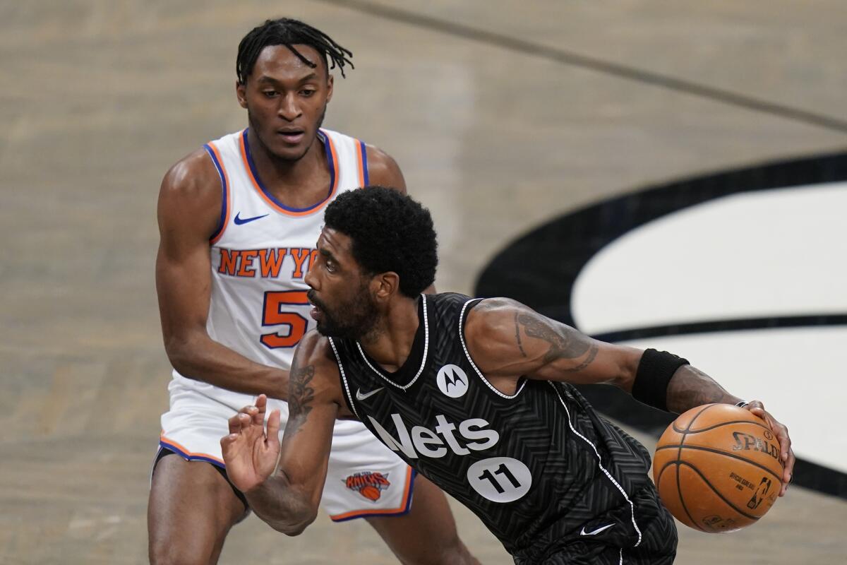 Brooklyn Nets' Kyrie Irving (11) drives past New York Knicks' Immanuel Quickley (5) during the first half of an NBA basketball game Monday, March 15, 2021, in New York. (AP Photo/Frank Franklin II)