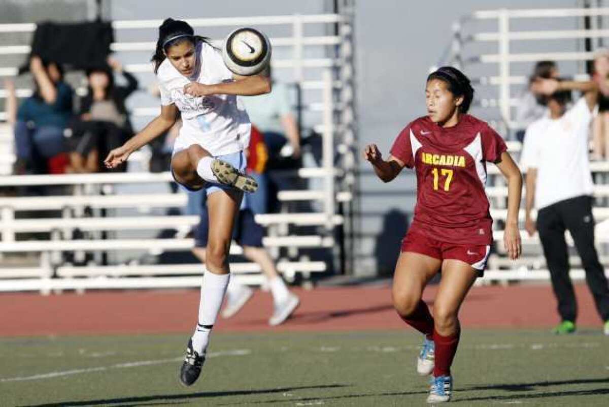 Crescenta Valley's Grace Keller, left, launched a shot on goal in the first half that was stopped by a diving Arcadia goalie.