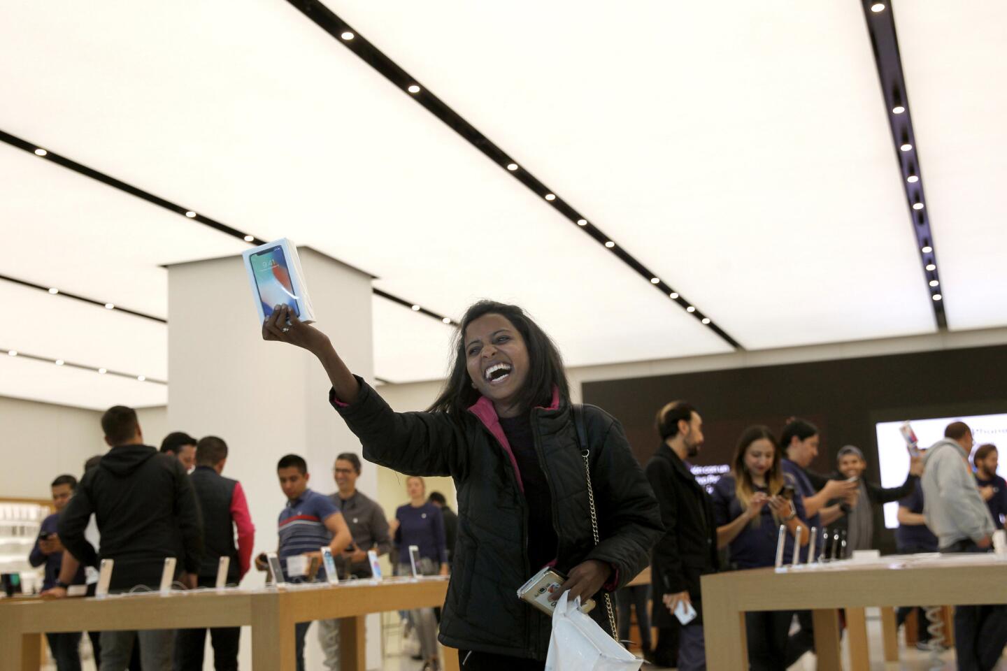 Una mujer muestra eufórica un iPhoneX que acaba de comprar en Ciudad de México, donde cientos de personas se dieron cita desde temprana hora, antes de que abrieran sus puertas los centros Apple, en la capital azteca.