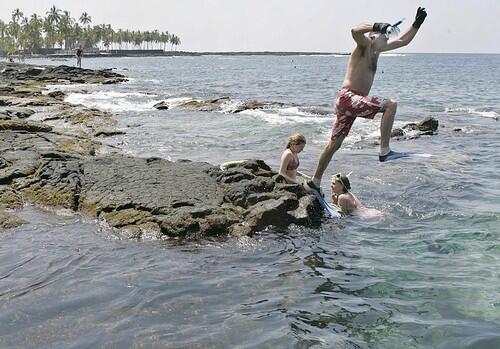 Snorkler getting into the water at Pu'uhonua O Hanaunau National Historical Park in South Kona.