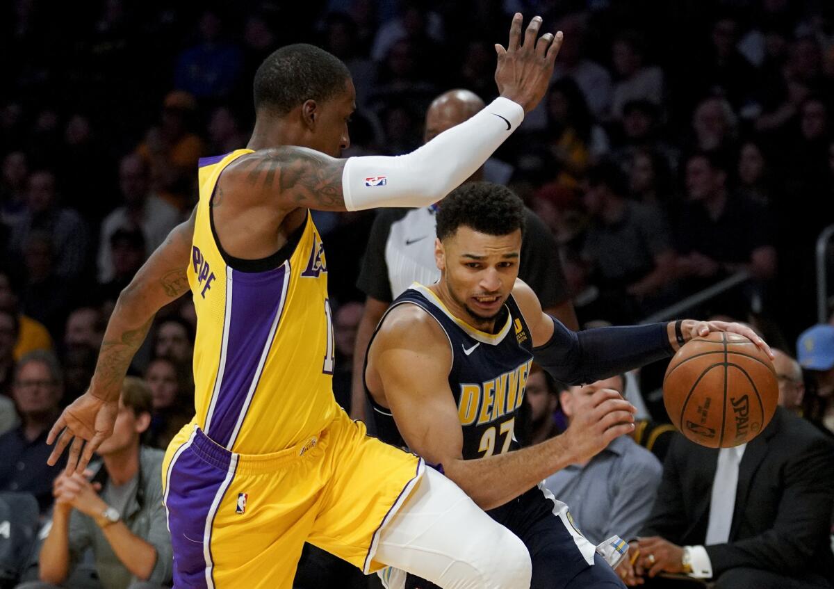 Denver Nuggets guard Jamal Murray, right, attempts to move past Los Angeles Lakers guard Kentavious Caldwell-Pope during the first half of an NBA basketball game in Los Angeles, Tuesday, March 13, 2018.